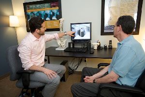 Chiropractor Canton MA Joel Favreau Consulting With Patient